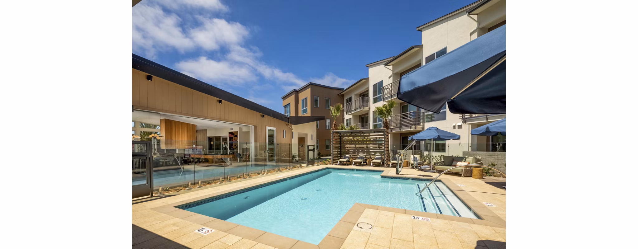 Resort-style pool at Triton Encinitas Apartments with lush landscaping and lounge areas
