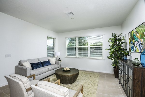 Spacious living room featuring modern decor and natural lighting at Alexander Park Apartments