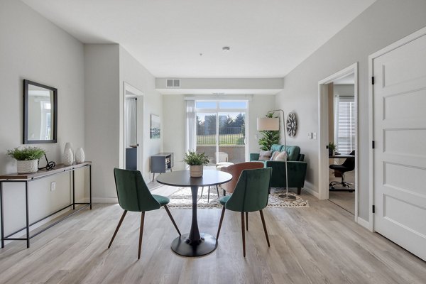 Dining area with modern furnishings at Arasan Apartments, featuring elegant lighting and open layout for Greystar luxury living