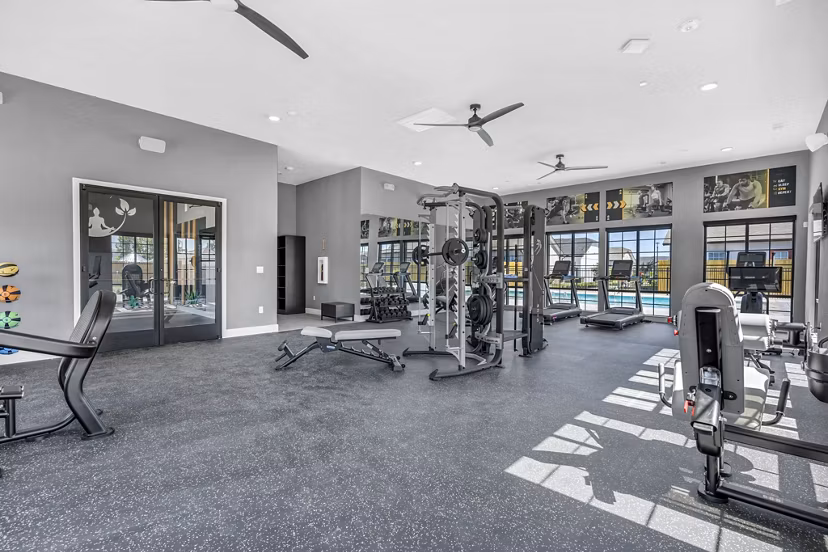 Fully-equipped fitness center at Preserve at Highway 6 Apartments featuring modern exercise machines and spacious workout areas