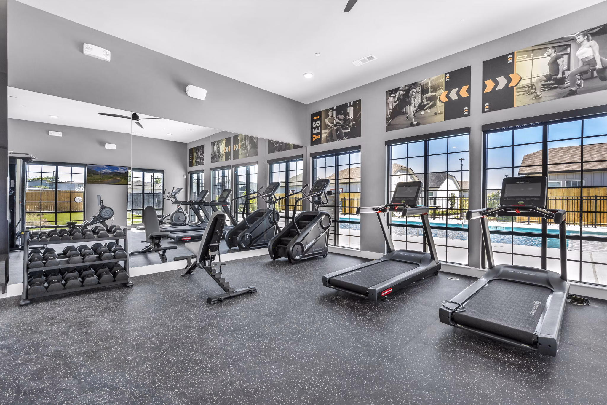Fully-equipped fitness center at Preserve at Highway 6 Apartments with modern exercise machines and free weights