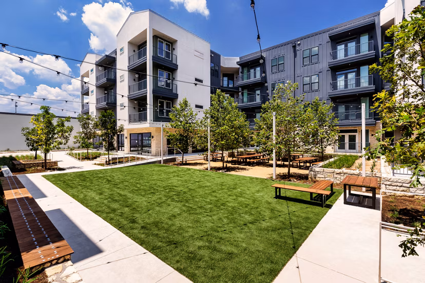 Courtyard with lush landscaping and seating area at Windsor Commons Apartments