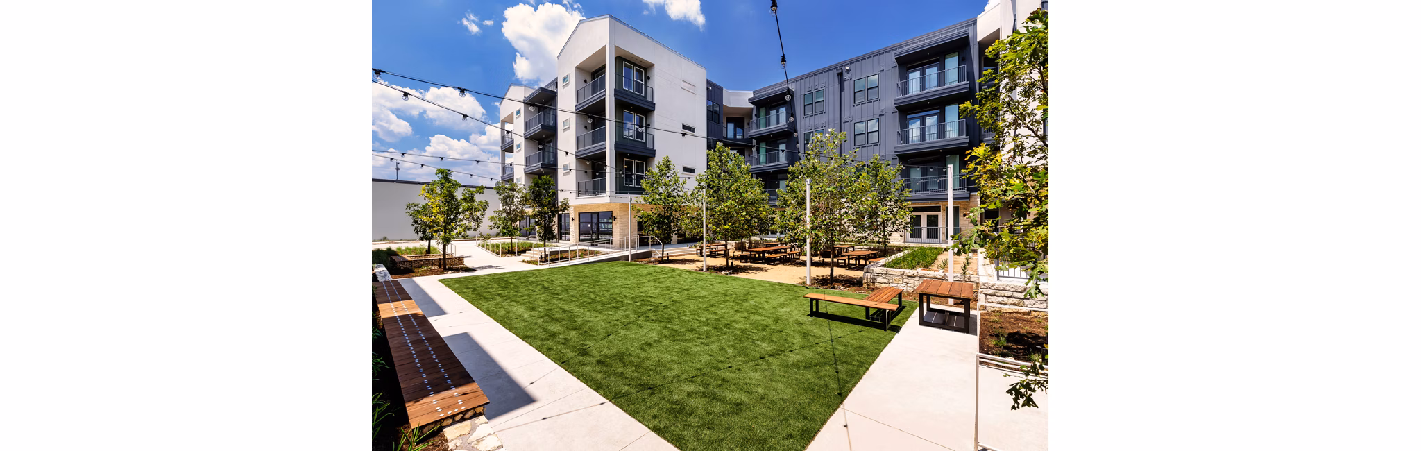 Courtyard with lush landscaping and seating area at Windsor Commons Apartments