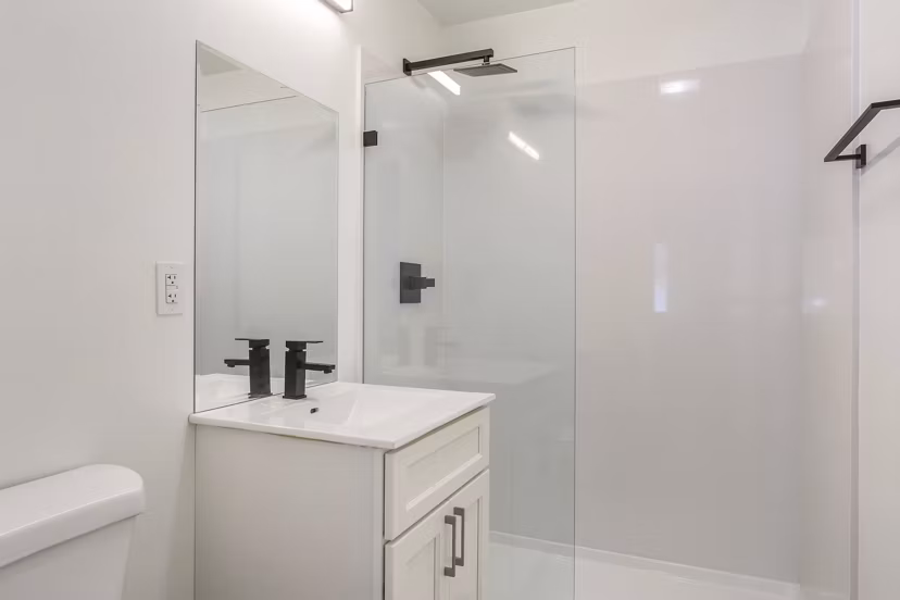 Modern bathroom with marble countertops and glass shower in Fremont City Center Apartments