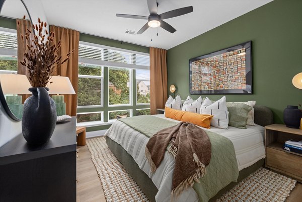 Cozy bedroom with contemporary design at The Point Apartments, featuring modern furnishings and ample natural light for luxury living