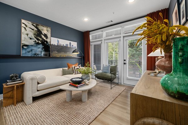 Spacious living room with modern furnishings and large windows at The Point Apartments