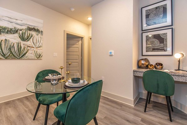 Dining area with modern furnishings and pendant lighting at Vibe Med Center Apartments, offering a stylish space for residents to enjoy meals together