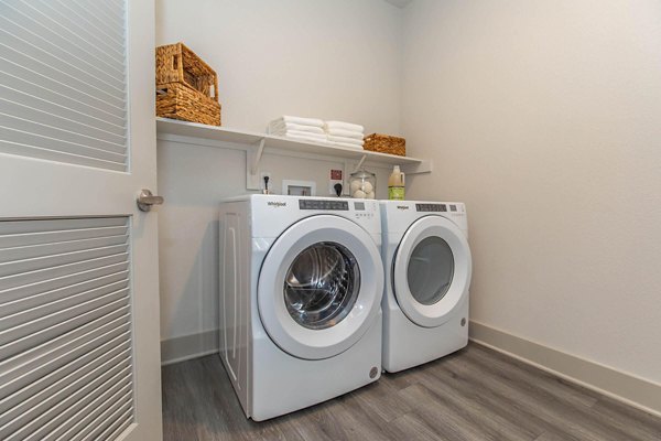 Modern laundry room with stainless steel appliances at Vibe Med Center Apartments