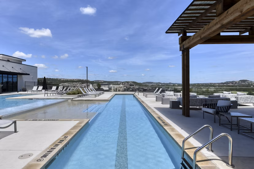 Scenic pool with lounge chairs at The Overlook at The Rim Apartments in San Antonio