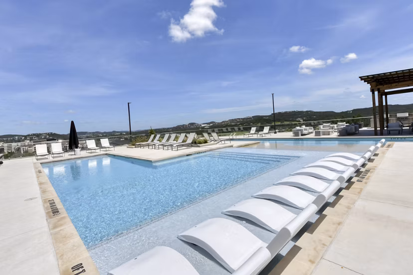 Resort-style pool with lush landscaping at The Overlook at The Rim Apartments, a luxury community offering premium amenities