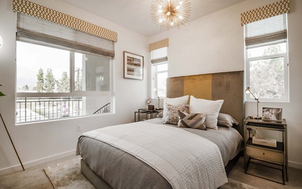 Cozy bedroom with modern design elements at MODA at Monrovia Station Apartments, featuring luxury decor and spacious sleeping area