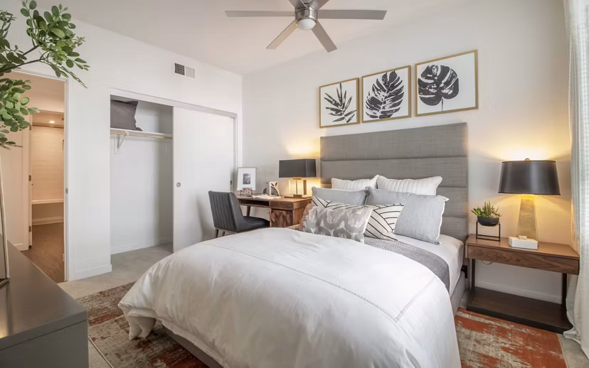 Bedroom featuring modern decor and large windows at MODA at Monrovia Station Apartments