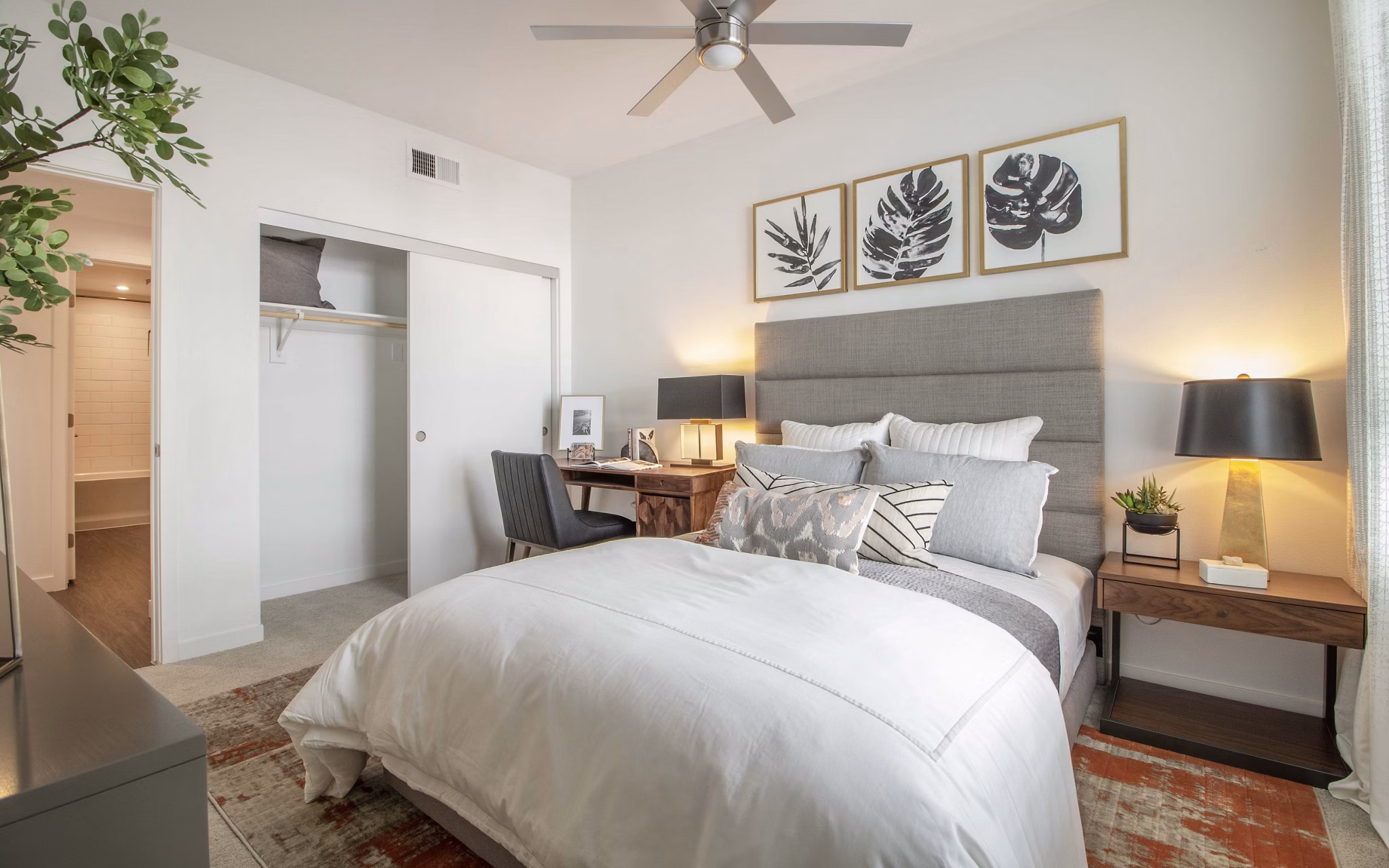 Bedroom featuring modern decor and large windows at MODA at Monrovia Station Apartments