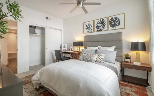 Bedroom featuring modern decor and large windows at MODA at Monrovia Station Apartments