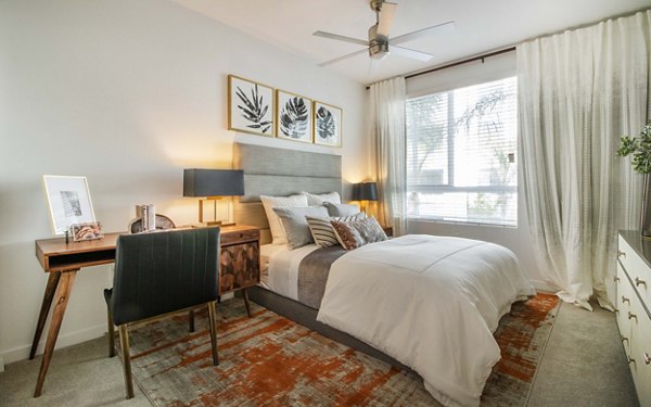 Cozy bedroom with modern decor at MODA at Monrovia Station Apartments featuring elegant design and comfortable furnishings