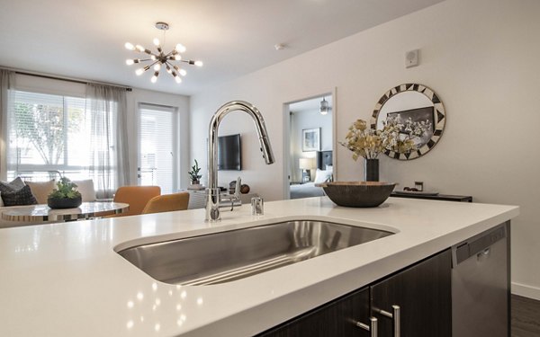 Modern kitchen with stainless steel appliances at MODA at Monrovia Station Apartments