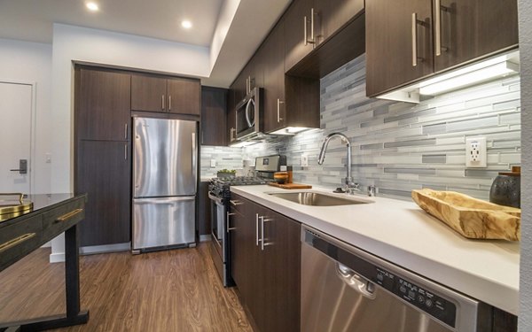 Contemporary kitchen with stainless steel appliances at MODA at Monrovia Station Apartments