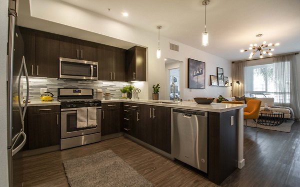 Modern kitchen with stainless steel appliances at MODA at Monrovia Station Apartments