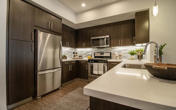 Modern kitchen with stainless steel appliances at MODA at Monrovia Station Apartments