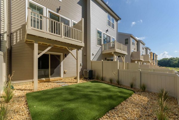 Charming patio with dining set and garden view at Brookestone Townhomes: luxury living in a serene environment