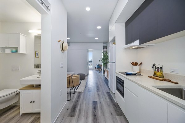 Modern kitchen with stainless steel appliances and granite countertops at 2911 Adams Apartments
