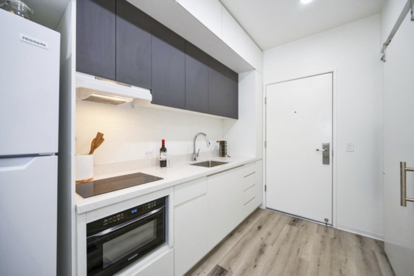 Contemporary kitchen with stainless steel appliances at 2911 Adams Apartments