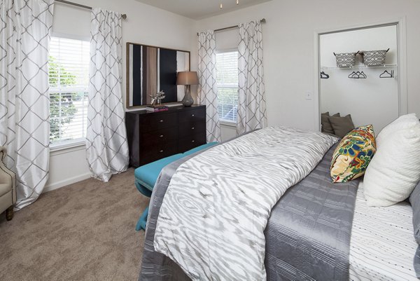 Bedroom featuring modern furnishings and natural light at Avana Portico Apartments