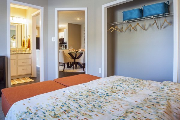 Cozy bedroom with modern decor at Avana Matthews Apartments, featuring plush bedding and ample natural light