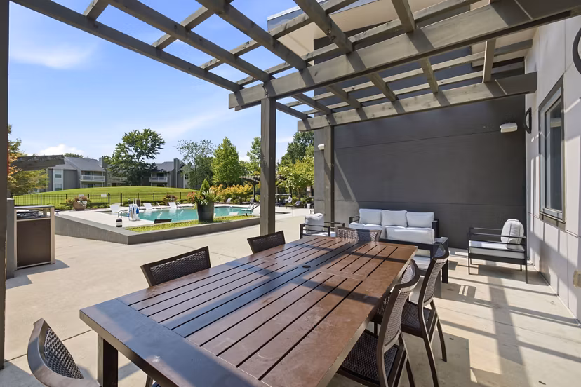 Patio with cozy seating and garden view at Avana Matthews Apartments
