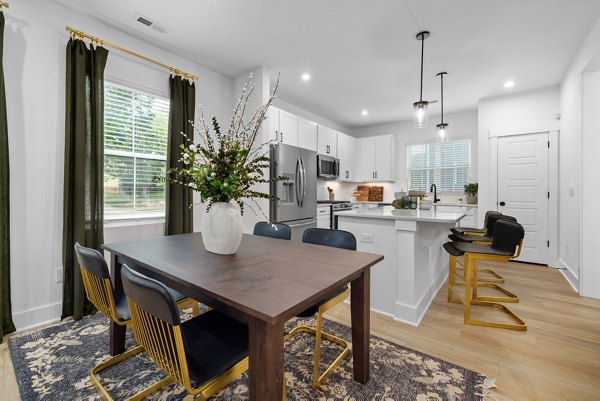Dining area featuring modern decor and high ceilings in ABODE at Hargett Apartments