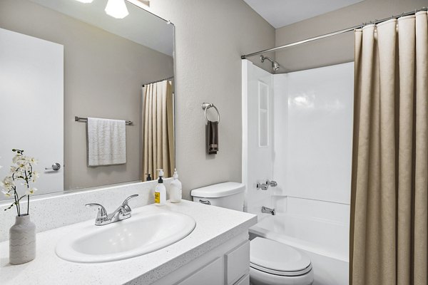 Bathroom featuring elegant fixtures and marble countertops at Coronado Palms Apartments