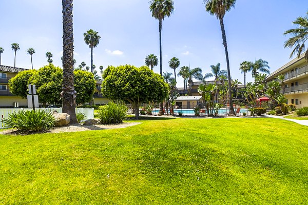 Coronado Palms Apartments: Lush courtyard with landscaped gardens and seating areas in a serene environment