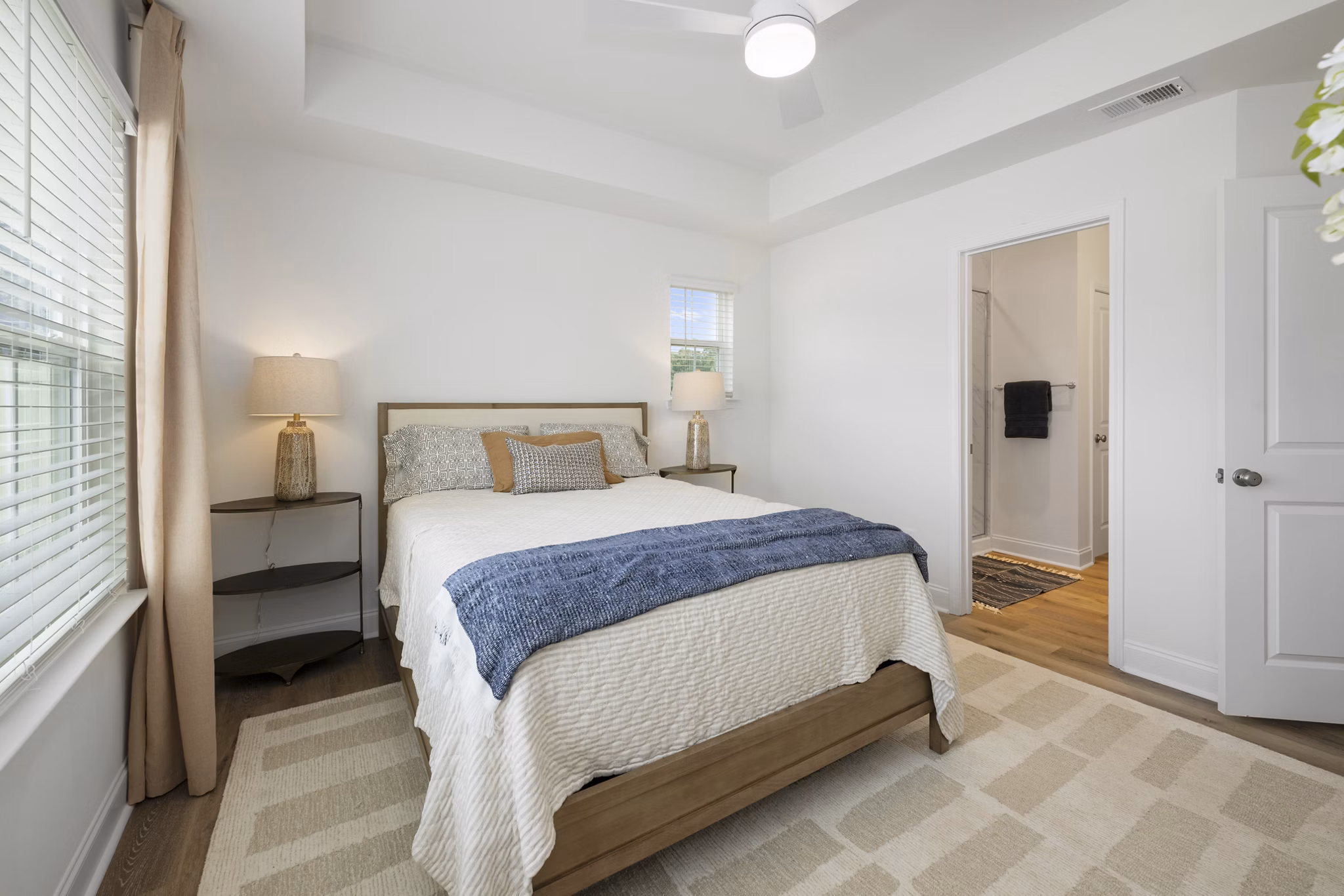 Spacious bedroom with modern decor and large window in Oak Lake Townhomes Apartments