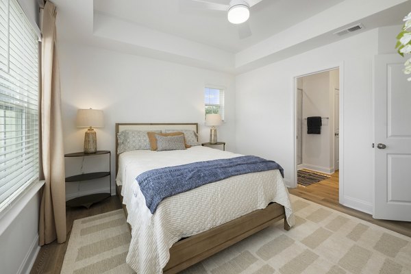 Spacious bedroom with modern decor and large window in Oak Lake Townhomes Apartments