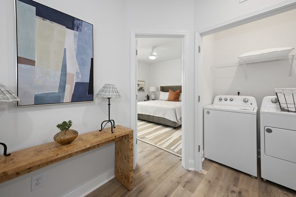 Laundry room featuring modern appliances in Oak Lake Townhomes Apartments