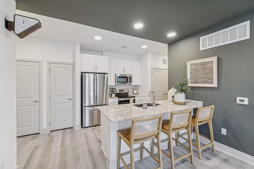Modern kitchen with stainless steel appliances in Alta Grandway Apartments, luxury living by Greystar