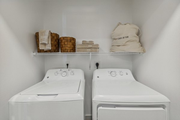 Laundry room featuring modern appliances at Alta Grandway Apartments