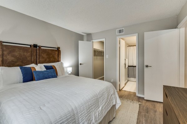 Cozy bedroom with stylish decor and ample natural light at Wood Hollow Apartments