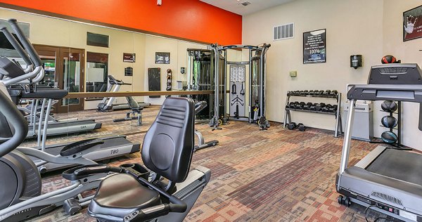 Fitness center with cardio machines and weights at Wood Hollow Apartments