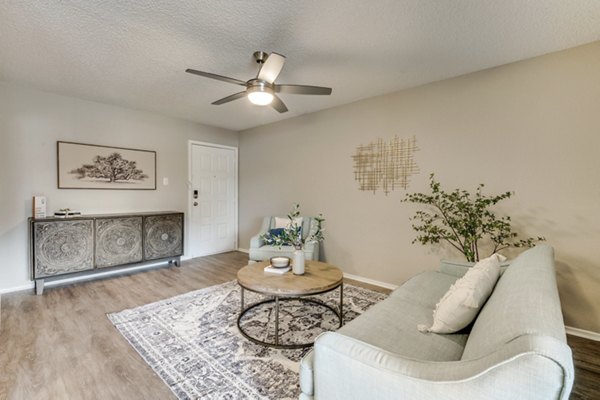 Cozy living room with modern decor and large windows at Wood Hollow Apartments