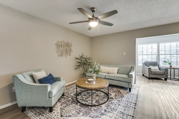 Spacious living room with modern decor in Wood Hollow Apartments, featuring stylish furnishings and ample natural light