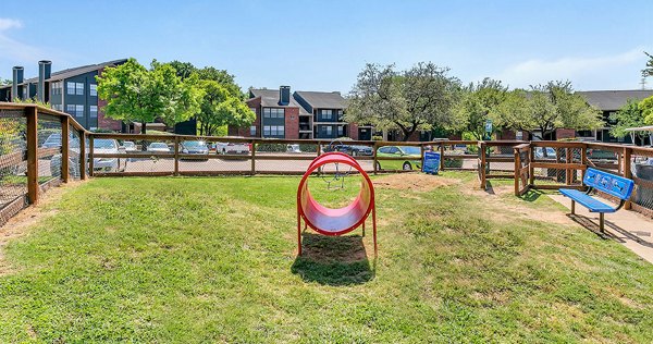 Expansive dog park surrounded by lush greenery at Wood Hollow Apartments