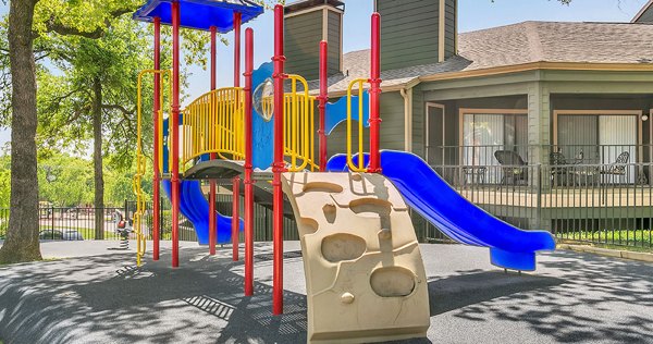 Wood Hollow Apartments: Children's playground featuring slides and swings in vibrant community setting