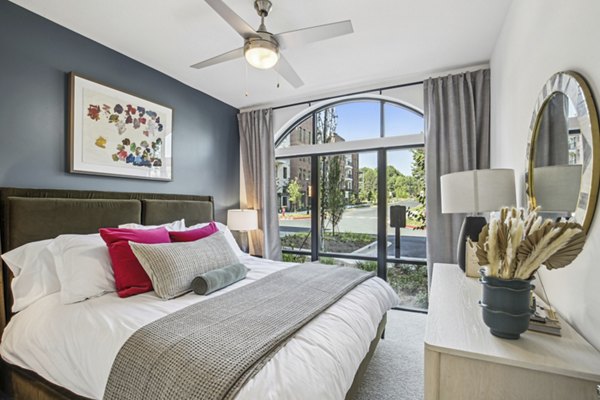 Cozy bedroom featuring a modern design and stylish furnishings at The Lacy at South Main Apartments