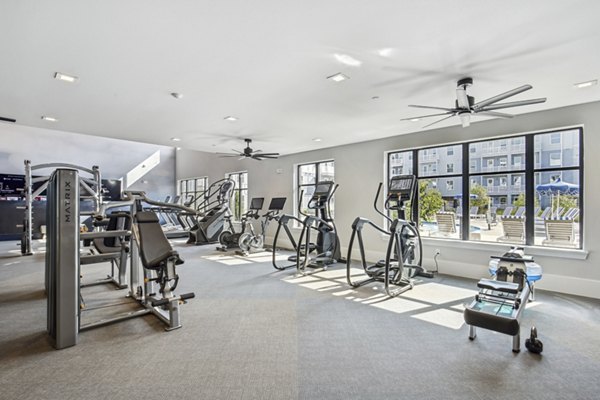 Fitness center at The Lacy at South Main Apartments with modern equipment and spacious layout for residents' wellness and exercise routines