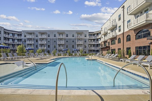 Modern outdoor pool surrounded by palm trees at The Lacy at South Main Apartments