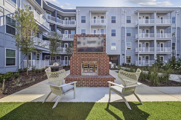 Recreational area with lush greenery and seating at The Lacy at South Main Apartments