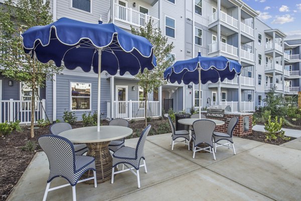 Outdoor grill area with modern seating at The Lacy at South Main Apartments, a luxury community offering premier amenities and stylish living spaces