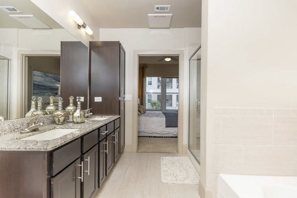 Modern bathroom with marble countertops and glass shower at Regency Park Apartments