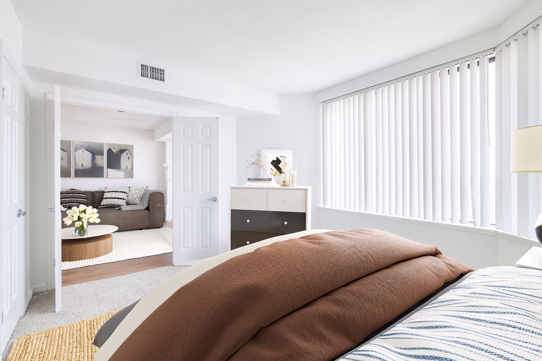 Cozy bedroom with stylish decor and large windows at Marlowe Apartments